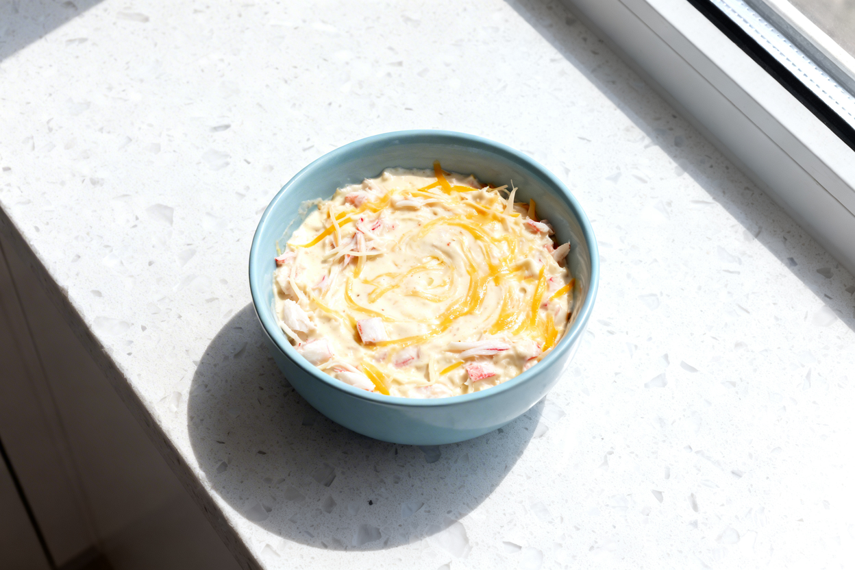 top-down food photo of a single serving of luxurious keto crab and cheese fondue in a light blue cer