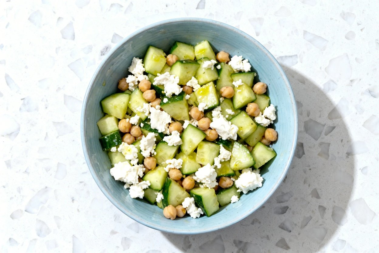 top-down food photograph of a finished keto cucumber feta chickpea salad: diced crisp cucumber chunk