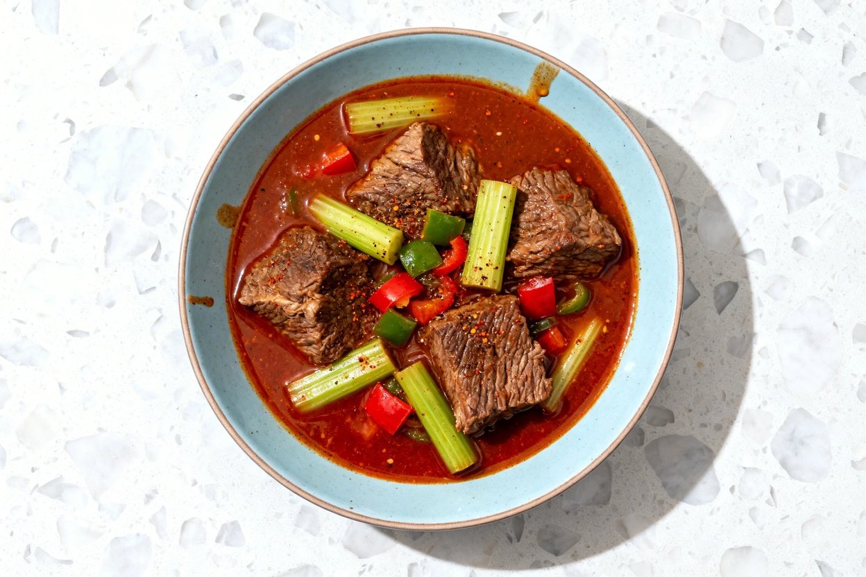 top-down food photo of a single serving of spicy keto beef stew: large, tender chunks of seared bee