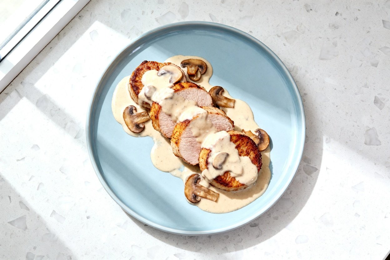 top-down food photograph of a single serving of keto seared pork tenderloin with creamy mushroom sau