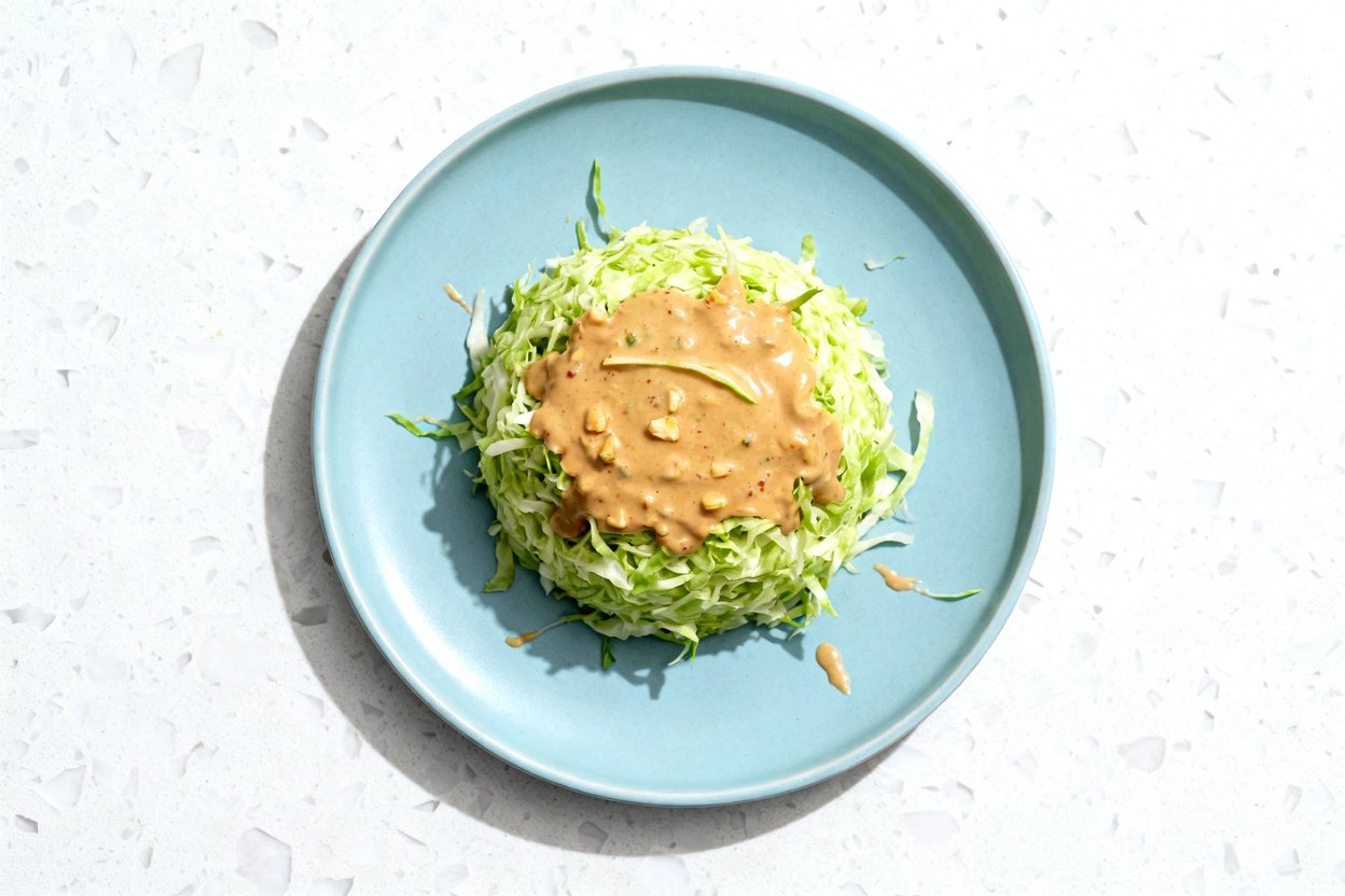 top-down food photo of a single serving Keto Thai Peanut Cabbage Salad on a light blue ceramic plate
