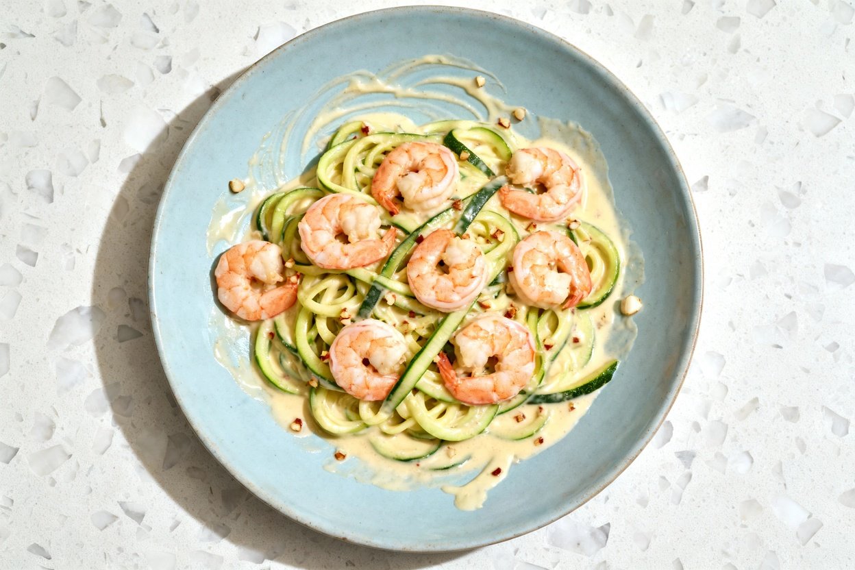 top-down food photo of a single serving of one-pot keto shrimp Alfredo with zoodles: zucchini noodle