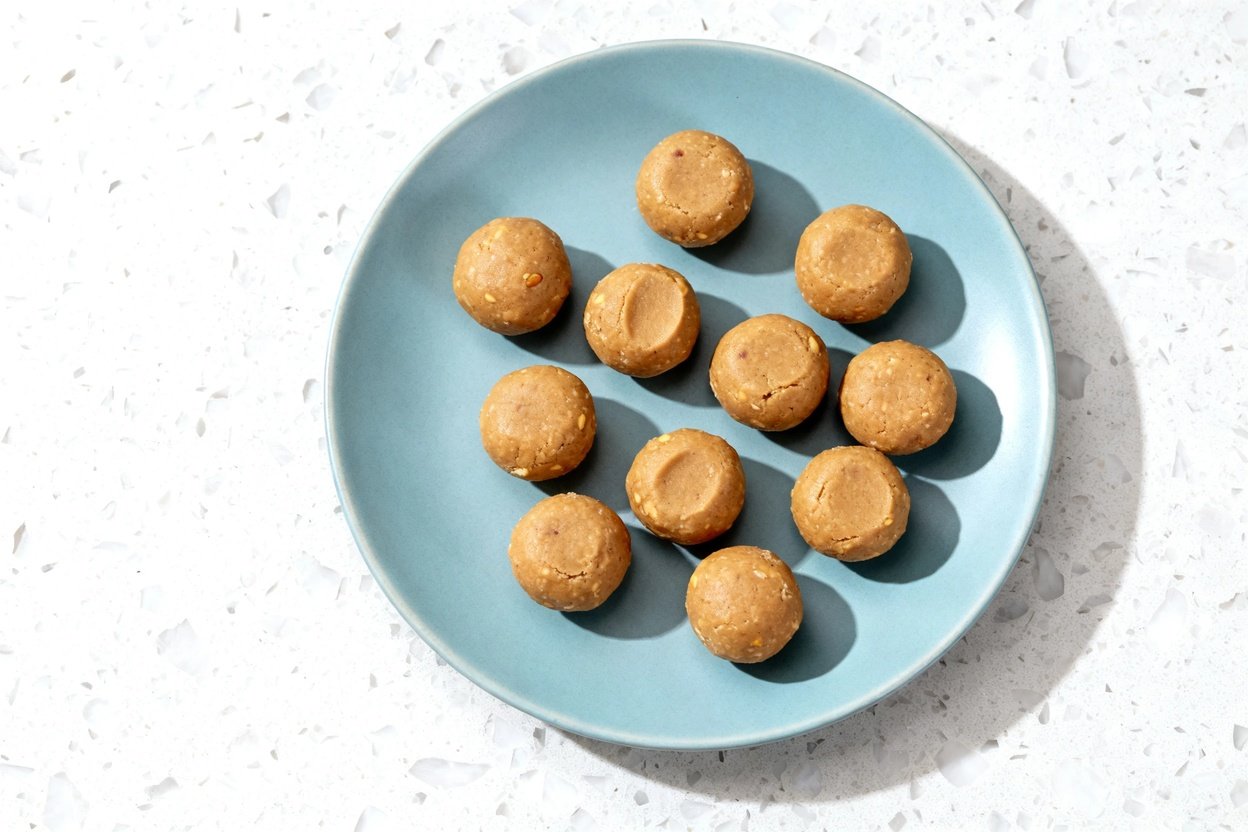 top-down food photo of a single serving of no-bake keto peanut butter bites: 9–10 bite-sized, unifor