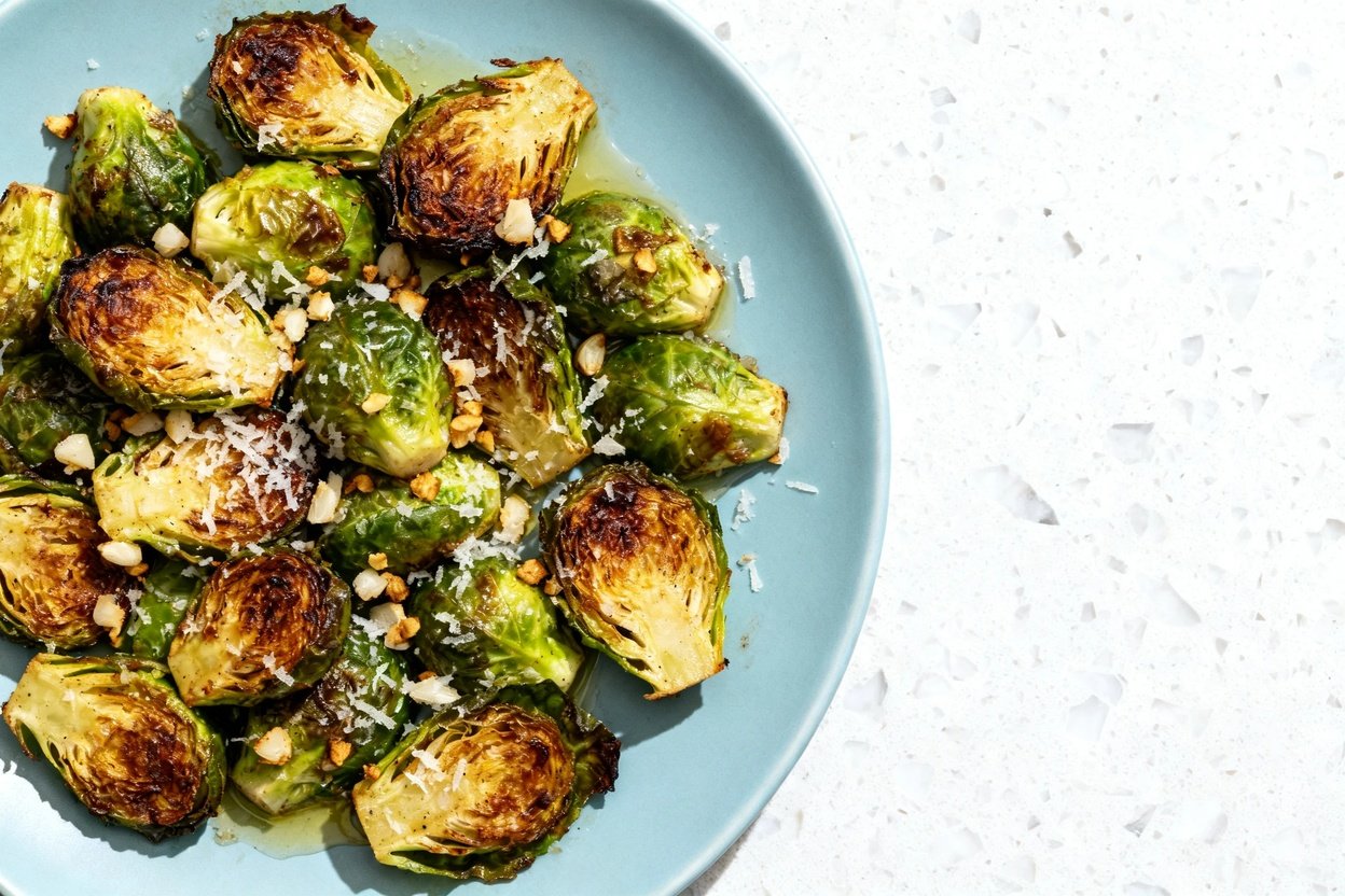 top-down food photo of a single serving of roasted Brussels sprouts tossed with minced garlic and f